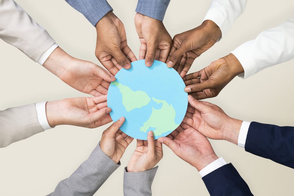 Manos formando un círculo alrededor de un icono del planeta, representando la misión y los valores de Grupo ISP
